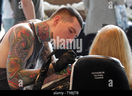 Un tatoueur est vu travailler sur un participant au cours de la Collection de tatouage à l'assemblée annuelle 15e Convention Internationale de tatouages à Kiev. Le festival rassemble des professionnels, tatouage fans et connaisseurs de l'art du tatouage du 17 au 19 mai 2019 à Kiev. Banque D'Images