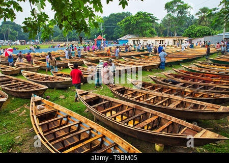 Des centaines de petits bateaux en bois vu affiché pour la vente à un marché que les sections locales à se préparer à la saison de la mousson. Des dizaines troupeau de loin pour acheter leur propre bateau à un marché en Manikganj, Bangladesh, de façon à être prête pour les inondations qui peuvent survenir à tout moment. Après de fortes pluies, il est courant que les berges des rivières pour éclater, submerger les villes et villages. Cela signifie que les voitures et les bus devenus superflus et les gens sont obligés de voyager par bateau. Chacun des bateaux en bois et avirons sont fait à la main par des artisans locaux et peut être acheté pour aussi peu que 1700 Taka bangladais - l'équivalent de 20 US dollar. Banque D'Images