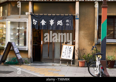 Un restaurant appelé tempura (徳仙 Tokusen) sur un corner de Rokku Dori à Asakusa, Tokyo. L'alimentation de l'échantillon dans la fenêtre et rideau noren sur la porte. Banque D'Images