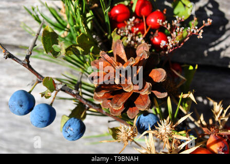 Couronne de Noël avec des baies sauvages (baies d'épine et dog rose baies), les cônes de pin gris, avec surface en bois, Close up detail Banque D'Images