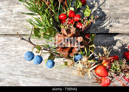 Couronne de Noël avec des baies sauvages (baies d'épine et dog rose baies), les cônes de pin gris, avec surface en bois, Close up detail Banque D'Images