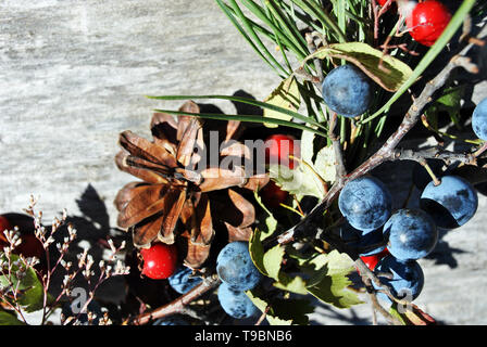 Couronne de Noël avec des baies sauvages (baies d'épine et dog rose baies), les cônes de pin gris, avec surface en bois, Close up detail Banque D'Images