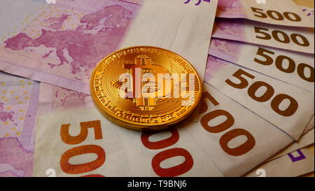 Les Bitcoins, une monnaie virtuelle en forme de pièce de monnaie physique, affichée sur 500 billets en euros Banque D'Images