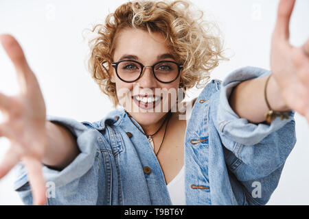 Sauter dans mes bras. Passionné et sympathique jeune belle petite amie blonde avec le maquillage et coiffure courte stretch lunettes Banque D'Images