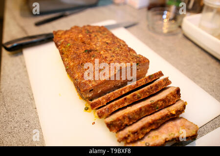 Coupe femme mains morceau de viande, elle se préparer pour une dégustation de nourriture à la cuisine. Coupe de viande avec le couteau chef à bord sur une cuisine de restaurant. Banque D'Images