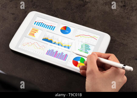 Femme d'affaires élégante de faire des diagrammes sur tablette avec un crayon Banque D'Images