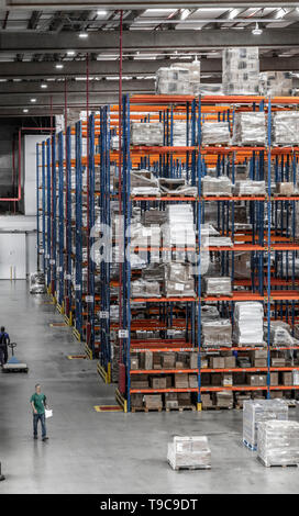 Les boîtes de distribution logistique remise et les travailleurs et à l'opération du chariot élévateur Banque D'Images