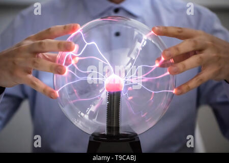 Close-up of Fortune Teller Holding Main sur la boule de cristal brillant Banque D'Images