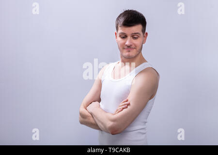 Close-up de l'homme heureux dans les bras croisés Tanktop Against White Background Banque D'Images
