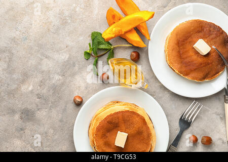 Les plaques avec de délicieuses crêpes à la citrouille sur la table Banque D'Images