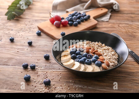 Gruau savoureux avec des tranches de banane, les bleuets et amandes sur table en bois Banque D'Images