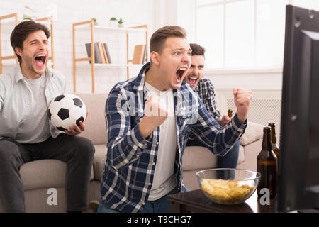 Nous gagner ! Les fans de football émotionnelle Regarder Match à la télévision Banque D'Images