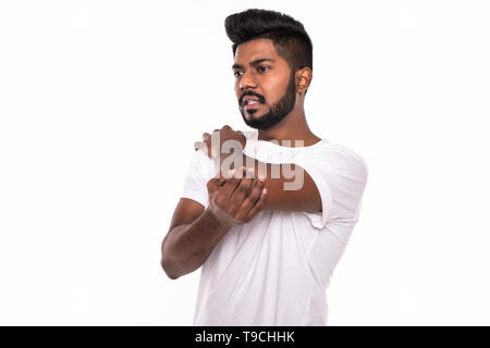 Bel homme indien ayant une douleur bras portrait studio sur fond blanc Banque D'Images