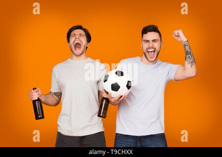 But ! Fans de football avec des bouteilles de bière et Ball célèbrent la victoire Banque D'Images