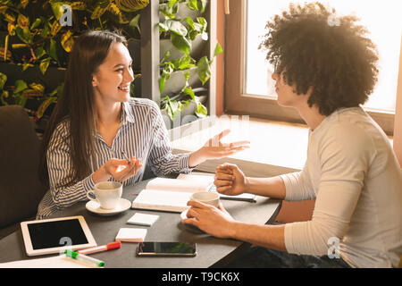 Cheerful woman avec nouveau candidat dans cafe Banque D'Images