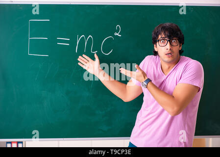 Jeune homme physic debout devant le conseil vert Banque D'Images