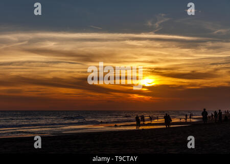 Plage de Berawa (Pantai Berawa) au coucher du soleil. Silhouettes de promeneurs sur. Canggu, Bali, Indonésie. Banque D'Images