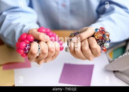 Woman squeezing balles anti-stress dans office, gros plan Banque D'Images