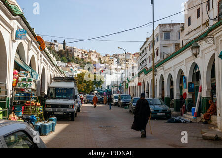 Des personnes non identifiées, marcher le long de la rue principale de Moulay Idriss, un jour ensoleillé. Moulay Idriss Zerhoun, le Maroc. Banque D'Images