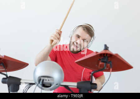 Les émotions, les passe-temps, de musique et de personnes concept - batteur émotionnel joue de la batterie électronique. Banque D'Images