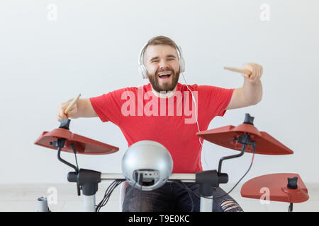 Émotions, batterie électronique et personnes concept - jeune homme batteur jouant du tambour. Banque D'Images