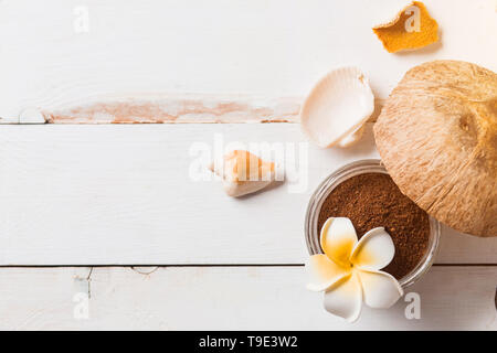 Des matières organiques naturelles gommage corps et visage de café moulu et d'huile de noix de coco. Composition du produit de beauté avec spa, de coquillages, d'orange, de fleur. F Banque D'Images