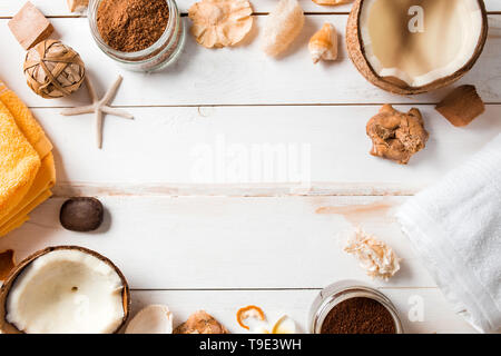 Cadre fait de cocotiers, , produits de beauté spa, des coquillages, des décorations sur fond de bois blanc. Mise à plat, vue du dessus, copiez l'espace. Une mer, Voyage Banque D'Images