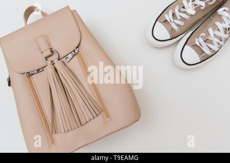 Espadrilles beige, sac à dos et une coiffe rose pastel sur fond clair. Place pour texte, copyspace, télévision lay Banque D'Images