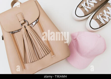 Espadrilles beige, sac à dos et une coiffe rose pastel sur fond clair. Place pour texte, copyspace, télévision lay Banque D'Images
