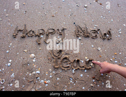 Texte de bonne année sur la plage de sable. Close up de dessin à la main avec bonne année sur le sable. Banque D'Images