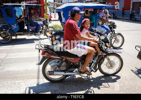 L'homme et la petite fille (sans doute père et fille) sans casque équitation une moto sur les rues animées de Yurimaguas, région de Loreto, au Pérou Banque D'Images