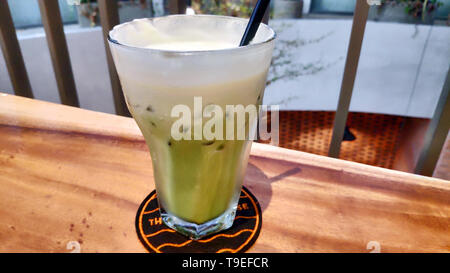 Matcha latte dans une tasse surmontée de mousse crémeuse, montrant une couleur verte vibrante et une texture lisse parfaite pour la photographie de boisson ou de café Banque D'Images