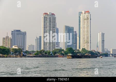 Bangkok, Thaïlande - 18 Avril 2018 : Skyline sur les rives de la rivière Chao Phraya avec bateaux et ses bâtiments modernes près du pont Taksin Banque D'Images