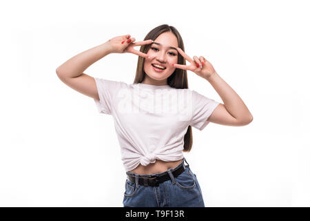 Portrait of asian girl in Casual t-shirt s'amusant et tenant deux doigts à son visage isolated over white background Banque D'Images