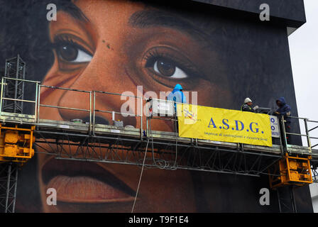 Agoch Jorit, 28, rue napolitaine est artiste de renommée internationale, père et mère néerlandaise. Il crée des peintures murales géantes sur les façades des immeubles de banlieue à travers le monde. Ses œuvres sont présentes à Buenos Aires, Córdoba, Aruba, Santiago du Chili, New York, Miami, Las Vegas, Los Angeles, San Francisco, Shenzhen, Gaza. En Italie Jorit est principalement actif à Naples où il fait d'immenses peintures sur façades aveugles des immeubles de banlieue et aussi dans le centre historique. Banlieue de Naples, bâtiments populaires de mauvaise réputation de Scampia trimestre. La peinture de Angela Davis. Banque D'Images