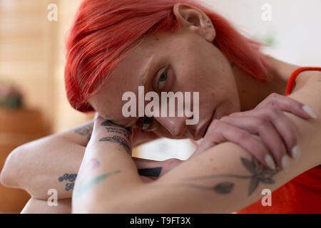 Red-haired woman with tattoos ressentir la douleur et la misère Banque D'Images