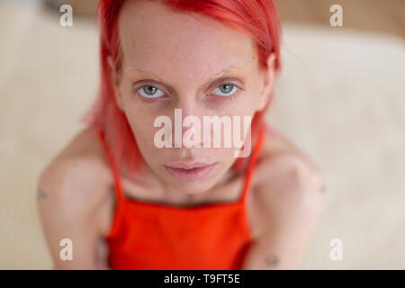 Aux yeux gris Skinny femme aux cheveux rouges qui souffrent d'anorexie Banque D'Images