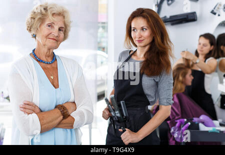 Portrait of female clients âgés et jeunes bienvenus hairstylist dans un salon de coiffure moderne Banque D'Images