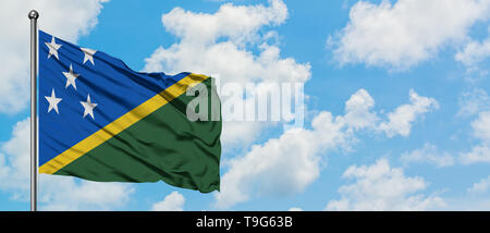 Îles Salomon drapeaux dans le vent contre blanc nuageux ciel bleu. Concept de diplomatie, de relations internationales. Banque D'Images