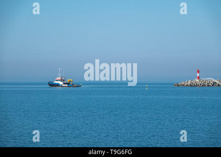 La mer remorqueur sort du port à côté du phare. Port de mer sur une journée ensoleillée. Banque D'Images