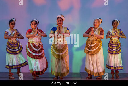 Un groupe de cinq danseuses Mohiniyattam interprétant une danse classique du sud de l'Inde sur scène dans une tenue traditionnelle kasavu blanche et dorée. Banque D'Images