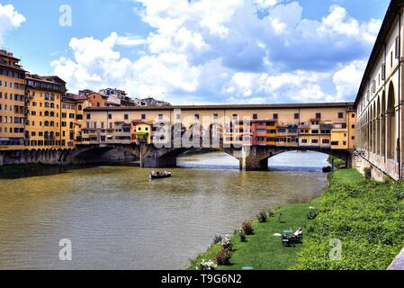 Florence, Italie - 10 mai 2018 : le Ponte Vecchio, un pont de pierre médiéval sur l'Arno qui n'a toujours construit des boutiques le long de celui-ci, avec la rivière b Banque D'Images