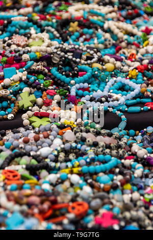 Bracelets et colliers colorés jeter sur une table dans un festival en plein air. Banque D'Images