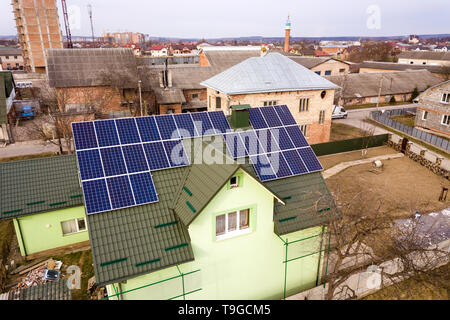 Vue aérienne de house cottage avec brillant bleu système de panneaux photovoltaïque sur le toit. La production d'énergie renouvelable écologique vert de concept. Banque D'Images