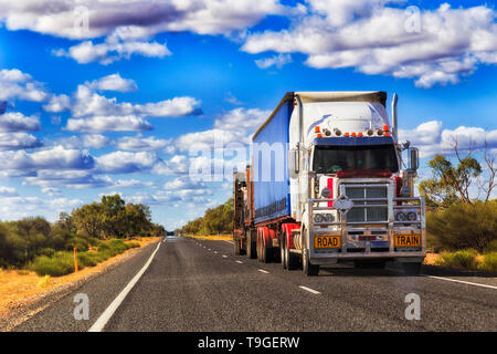 Mighty long road de chariot en mouvement du fret à travers l'Australie sur une autoroute vide solitaire en milieu rural , de l'outback. Banque D'Images