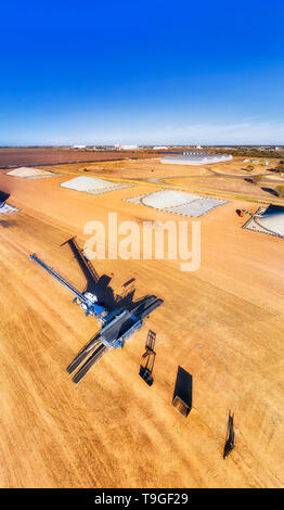 Les machines industrielles et de stockage en vrac de céréales le chargeur en place d'entrepôt au milieu de la ceinture de blé dans la région agricole de base artésiens outback rural Banque D'Images