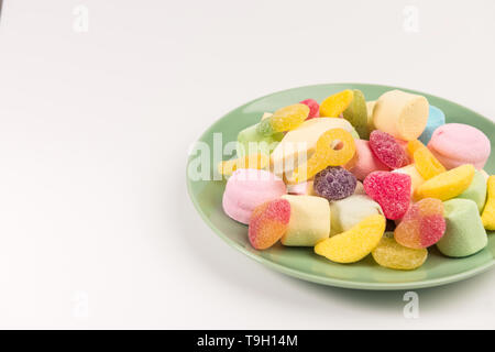 La plaque avec les sucreries isolé sur un fond blanc. Bonbons gommeux et guimauve. Banque D'Images