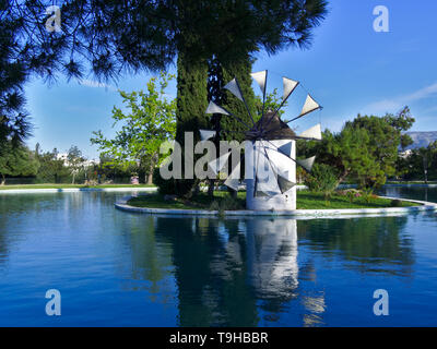 Beau moulin blanc sur la petite île à l'intérieur d'un lac du parc. Alsos Filadelfeias, Athènes, Grèce. Banque D'Images