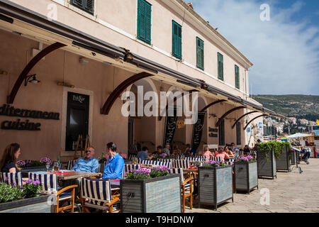 DUBROVNIK, CROATIE - AVRIL, 2018 : les touristes dans un restaurant situé au Vieux Port de Dubrovnik dans un beau jour de printemps Banque D'Images