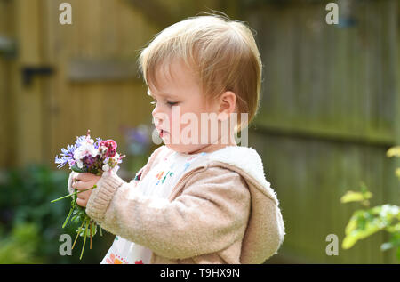 Jeune bébé fille de deux ans et demi de préparation de l'âge de fleurs jardin de Gaulle Charles Banque D'Images